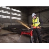 Pracownik w kasku z Milwaukee M18 ONEFLAG230XPDB w hali konstrukcji stalowych