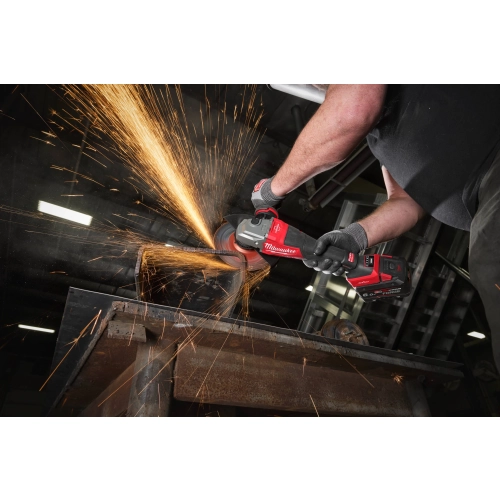 Pracownik tnie Milwaukee M18 FHSAGO180VXPDB2 stalowy element, snop iskier