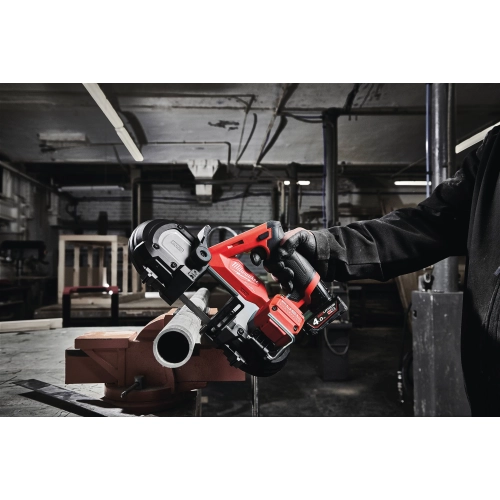 Milwaukee M12 FBS64 tnie rurę stalową zamocowaną w imadle w warsztacie