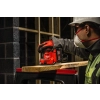 Pracownik w masce szlifuje Milwaukee M18 BQSS deskę na stole