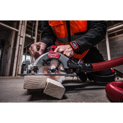 Milwaukee M12 FCS442 z wężem odkurzacza tnie deskę na budowie