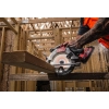 Pracownik tnie Milwaukee M18 FCS552 deskę na kozłach, trociny lecą na bok