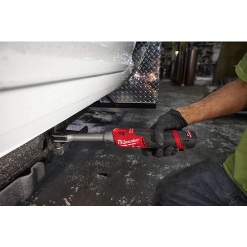 Mechanik pracuje Milwaukee M12 FPTR pod pojazdem przy krawędzi nadwozia