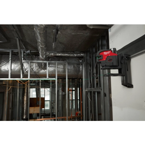 Laser Milwaukee M12 CLL4P zamocowany wysoko na ścianie przy instalacjach