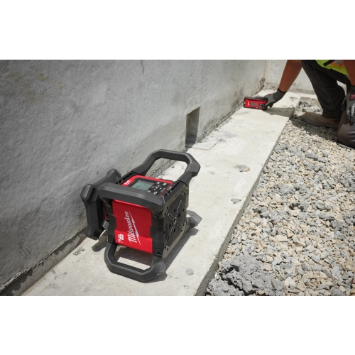 Niwelator Milwaukee M18 RLOHV1200 leży na boku przy ścianie w trybie pionowym