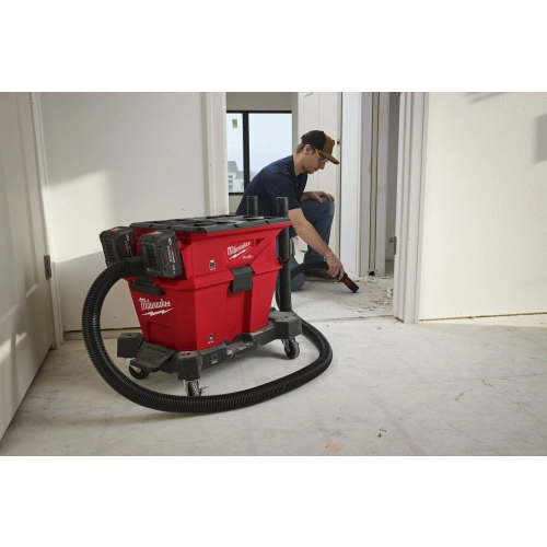 Monter odkurza przy drzwiach, odkurzacz Milwaukee M18 F2VC23LG2 stoi w pokoju