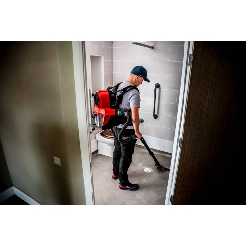 Pracownik z Milwaukee M18 FBPV2 odkurza łazienkę
