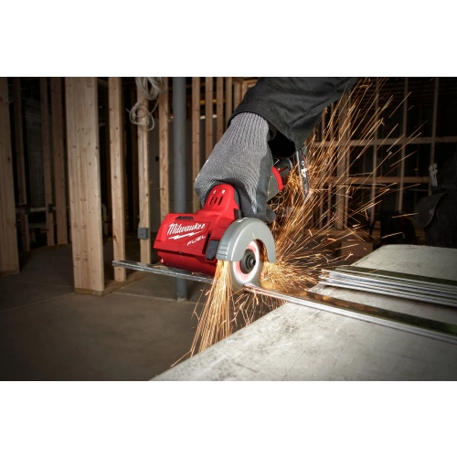 Milwaukee M12 FCOT tnie stalowy ceownik, snop iskier, w tle konstrukcja drewniana