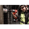 Pracownik w kasku wycina otwornicą HOLE DOZER Milwaukee M12 FDD2 otwór w drewnianej konstrukcji