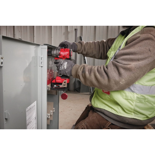Elektryk wkręca Milwaukee M18 ONEDD3 w obudowie rozdzielni