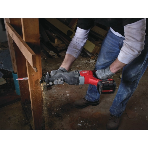 Pracownik tnie Milwaukee M18 BSX belkę podwaliny przy ścianie w remontowanym domu