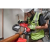 Instalator w kasku tnie Milwaukee M18 FBS127 grubą rurę miedzianą trzymaną ręką