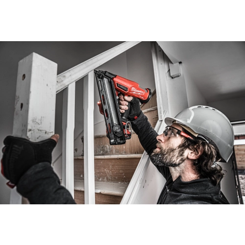 Milwaukee M18 FN15GA wbija gwóźdź w słupek balustrady schodów