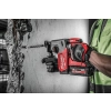 Milwaukee M18 ONEFH wierci wiertłem SDS-Plus otwór w betonowej ścianie, ręka na rękojeści bocznej
