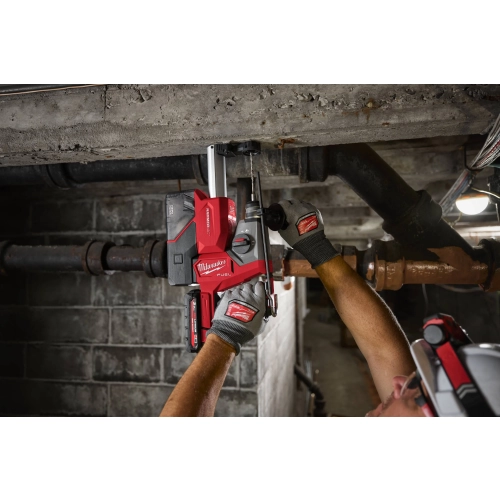 Milwaukee M18 FHAC16 wierci nad głową w betonowym stropie między rurami instalacji