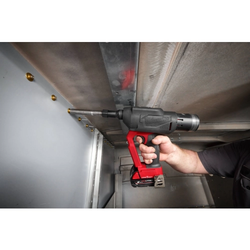 Milwaukee M18 ONEFLT pracuje przy suficie wnętrza naczepy
