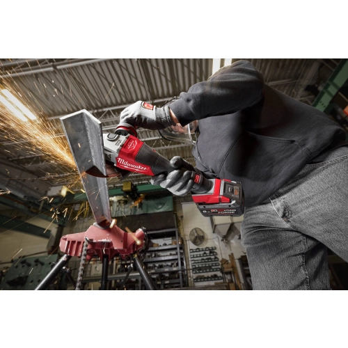 Pracownik szlifuje Milwaukee M18 FHSAG125XPDB2 krawędź wyciętej blachy