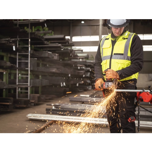 Pracownik tnie Milwaukee M18 FHSAGO125VXPDB2 profil w magazynie stali