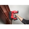 Milwaukee M18 FN18GS mocuje ciemną drewnianą listwę do ściany