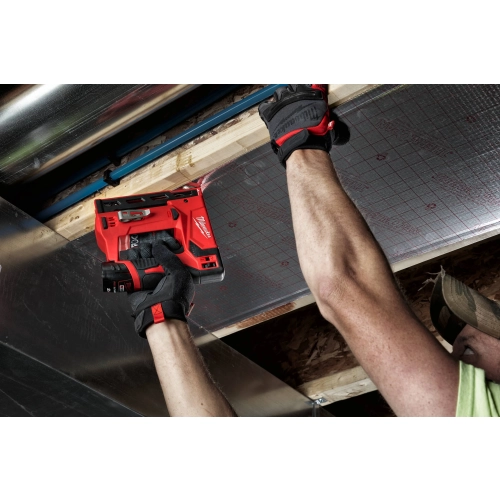 Milwaukee M12 BST mocuje folię na izolacji sufitu nad głową
