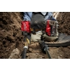 Pracownik w wykopie dokręca Milwaukee M18 FIW2F12 śrubę przy rurze