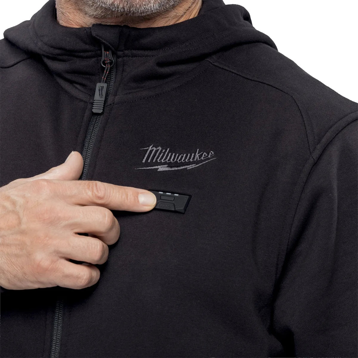 Palec na przycisku sterowania grzaniem na piersi bluzy podgrzewanej Milwaukee M12 HHBL5