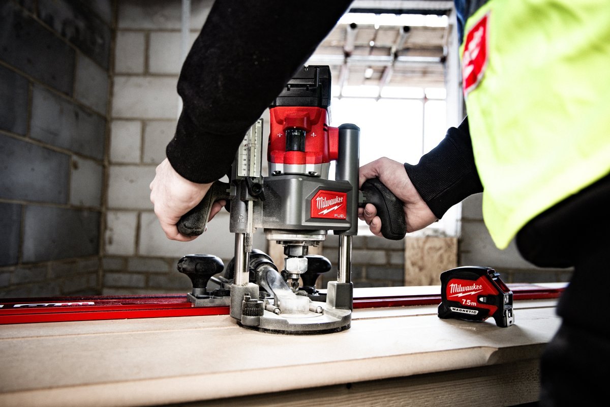 Frezarka Milwaukee M18 FUEL FR12 na szynie z podłączonym wężem odkurzacza, czysta linia frezowania