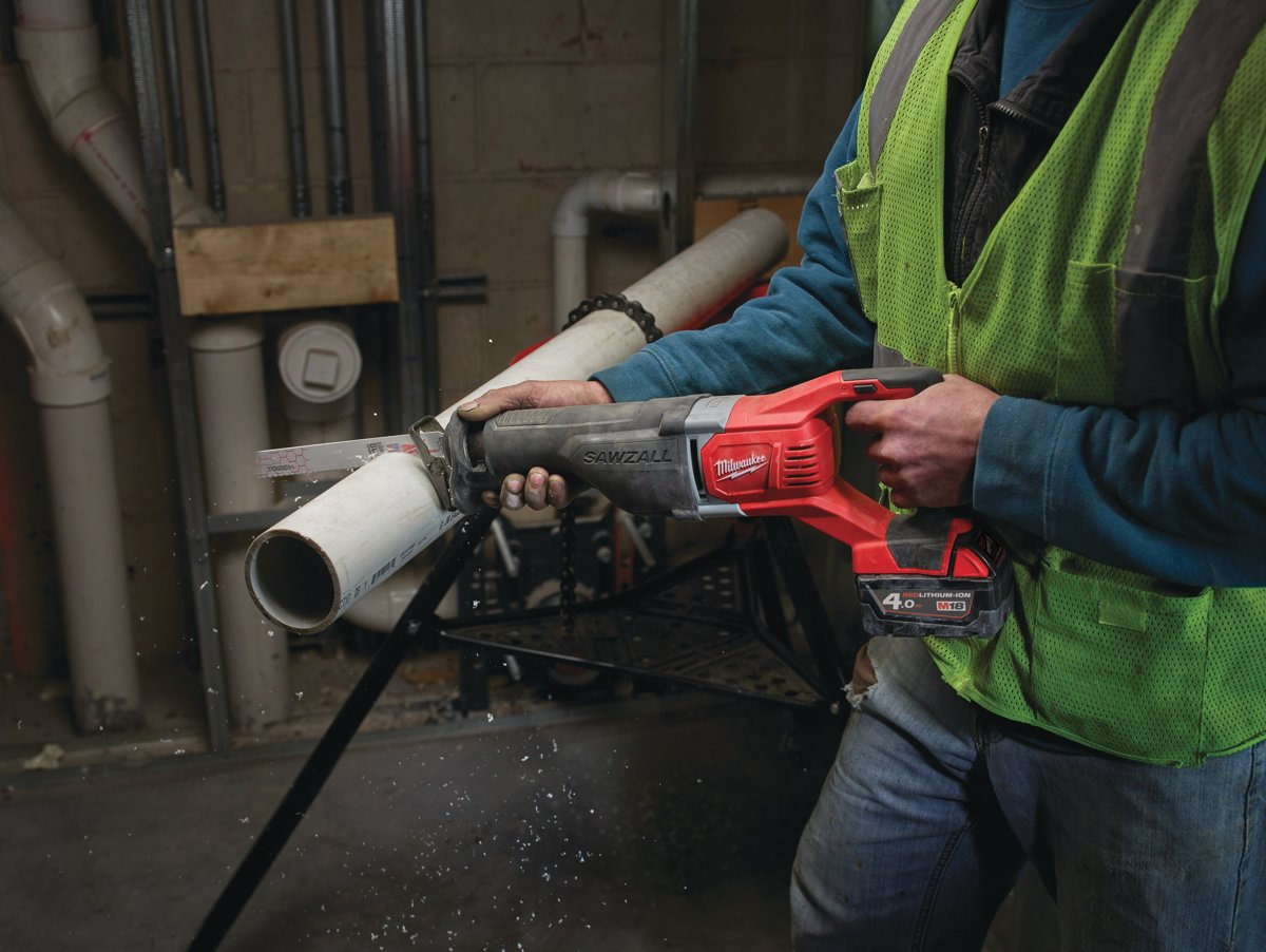 Pracownik tnie rurę PCV na stojaku piłą szablastą Milwaukee M18 BSX SAWZALL