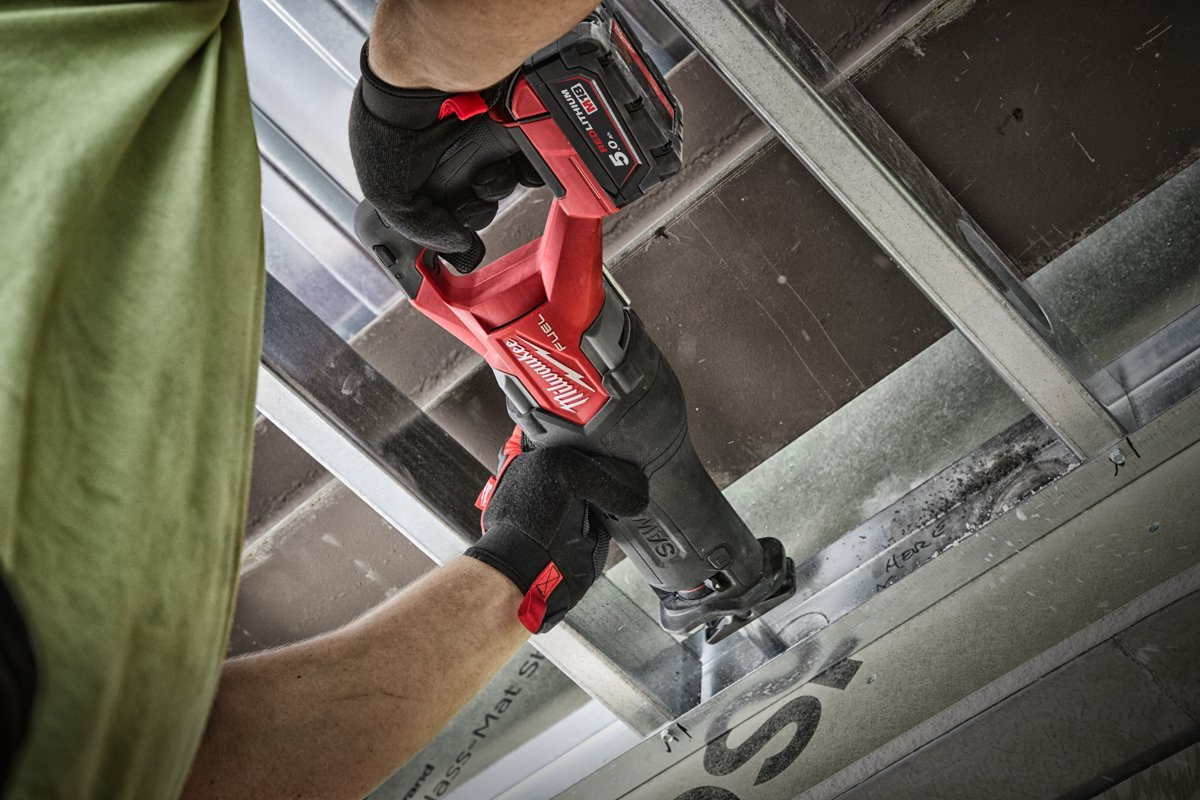 Monter tnie profil stalowy przy suficie piłą szablastą Milwaukee M18 FUEL SAWZALL