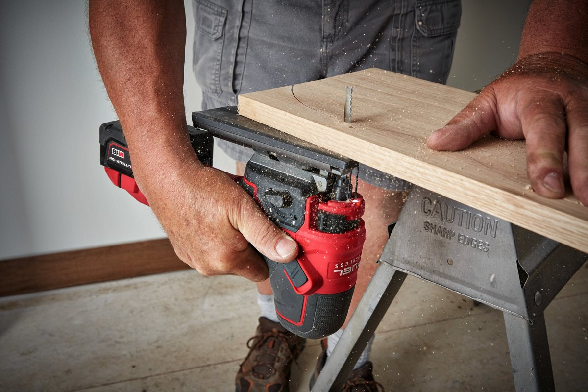 Cięcie deski od spodu wyrzynarką Milwaukee M18 FUEL FBJS trzymaną za korpus