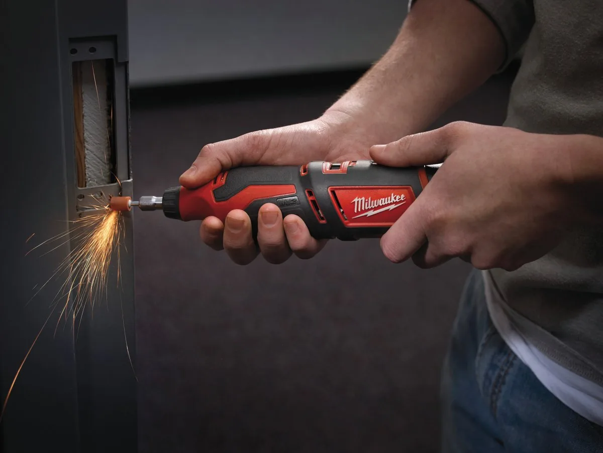 C12 RT tarczą tnącą przecina element metalowy w otworze ściany, lecą iskry