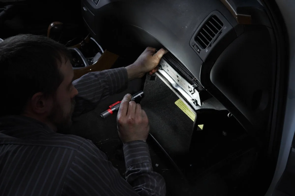 Mechanik sprawdza deskę rozdzielczą samochodu z latarką IPL-LED