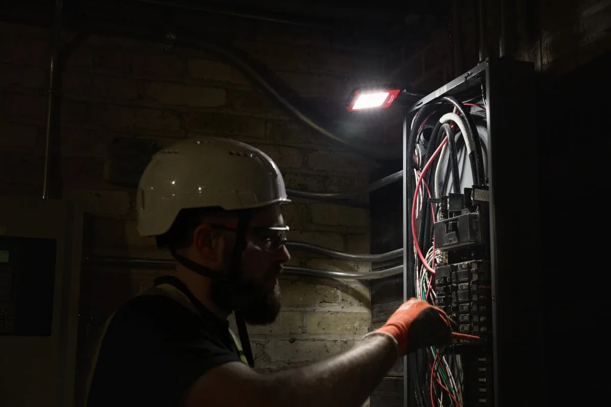 Elektryk przy rozdzielnicy oświetlonej reflektorem IR FFL