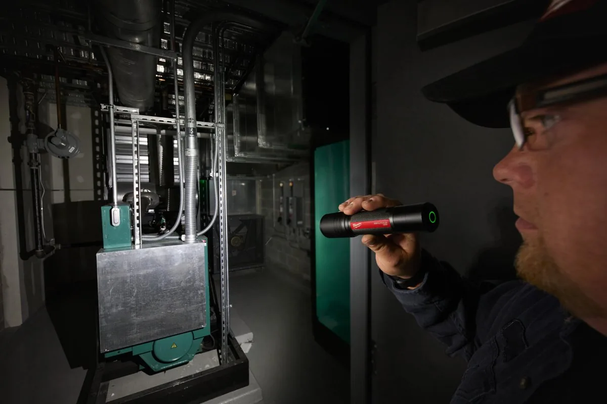 Elektryk sprawdza rozdzielnię z latarką L4 FL2000