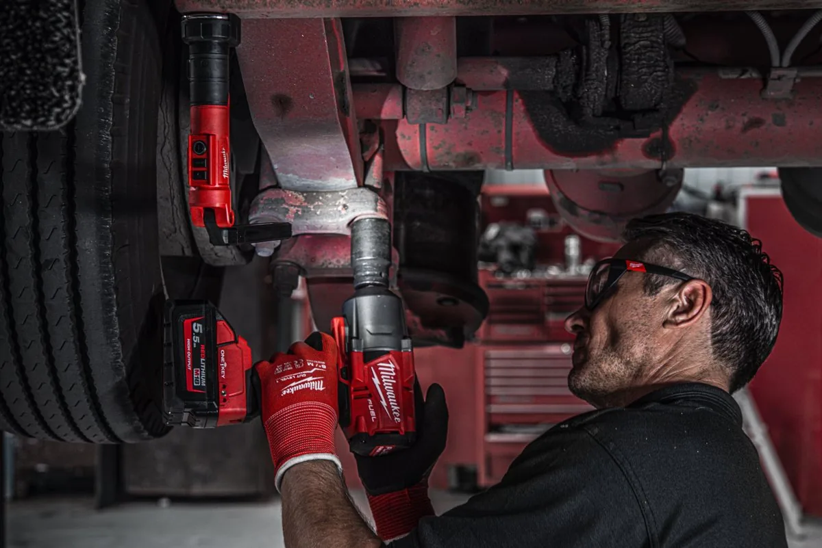 Mechanik dokręca koło ciężarówki przy świetle latarki L4 SL550