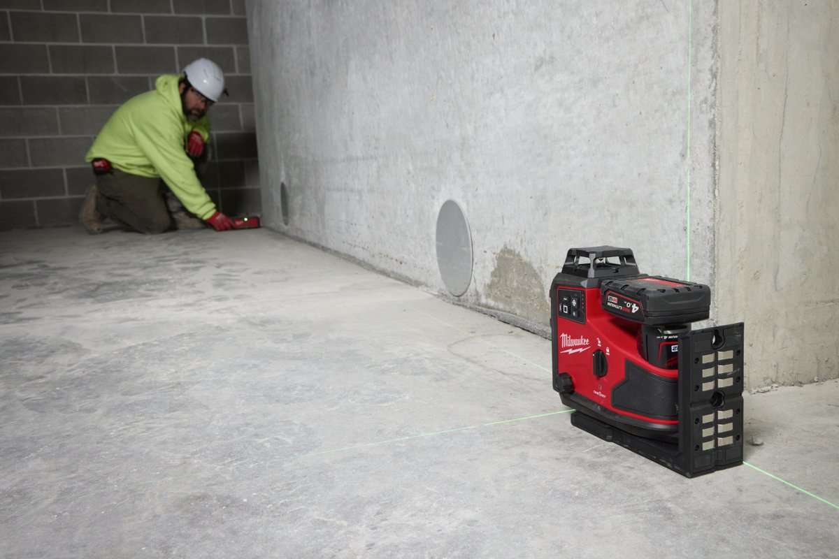Monter zaznacza linię przy betonowej ścianie według lasera M12 A3PLO