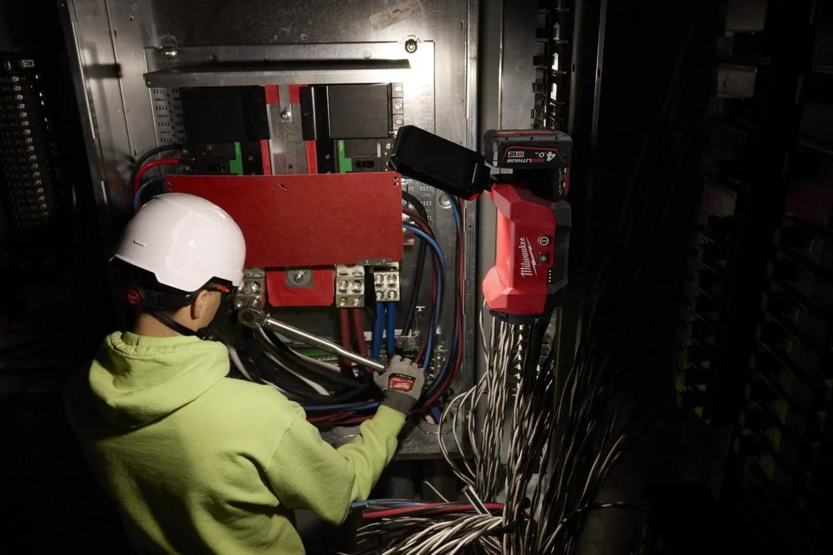Elektryk w rozdzielni oświetlonej reflektorem M12 ALIP