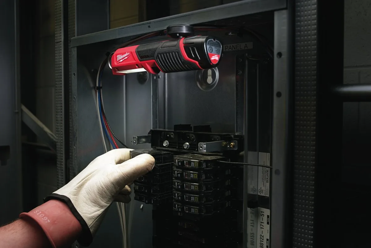Elektryk pracuje w rozdzielni przy świetle latarki M12 SL