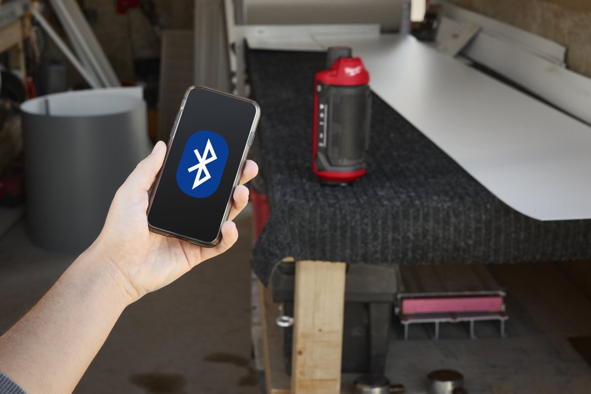 Telefon z logo Bluetooth przy głośniku M12 SPEJSG2 na stole