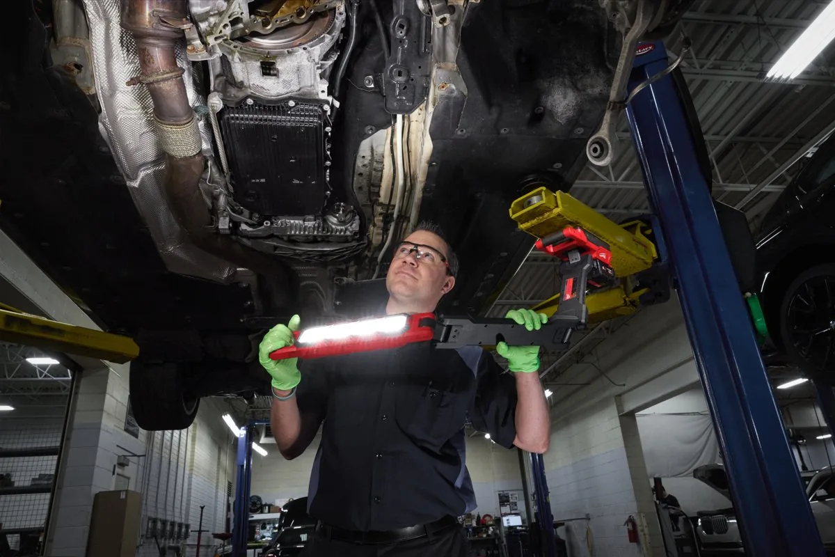 Mechanik pod autem na podnośniku przy świetle lampy M18 ABL