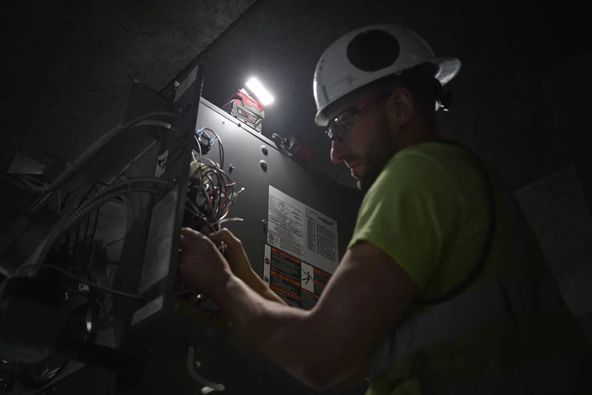 Elektryk w szafie sterowniczej z reflektorem M18 ALIS