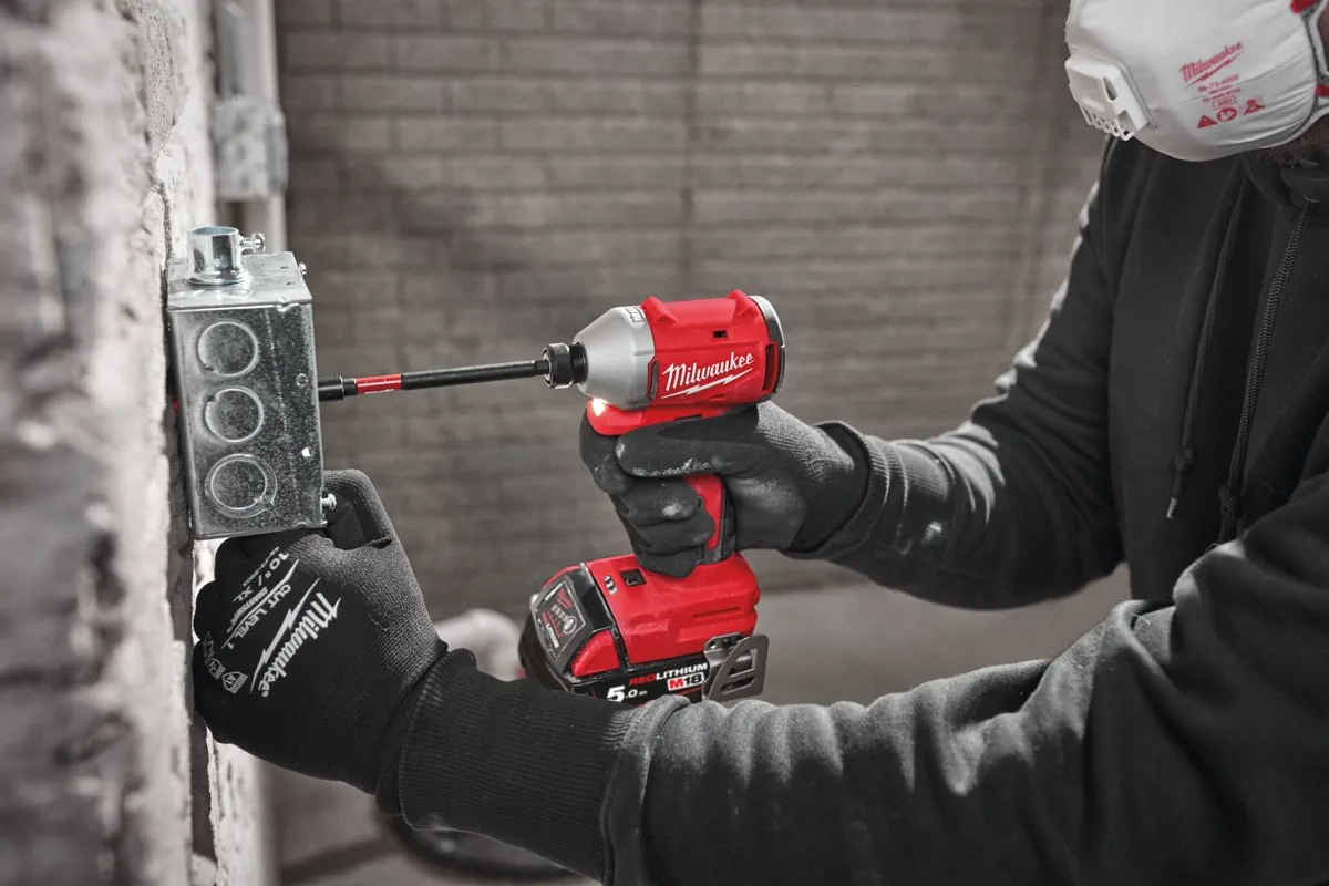 M18 BLIDR wkręca wkręt w puszkę elektryczną na ceglanej ścianie