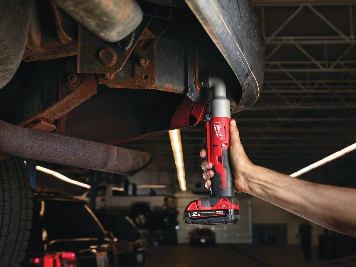 Mechanik dokręca M18 BRAIW nakrętkę pod podwoziem ciężarówki