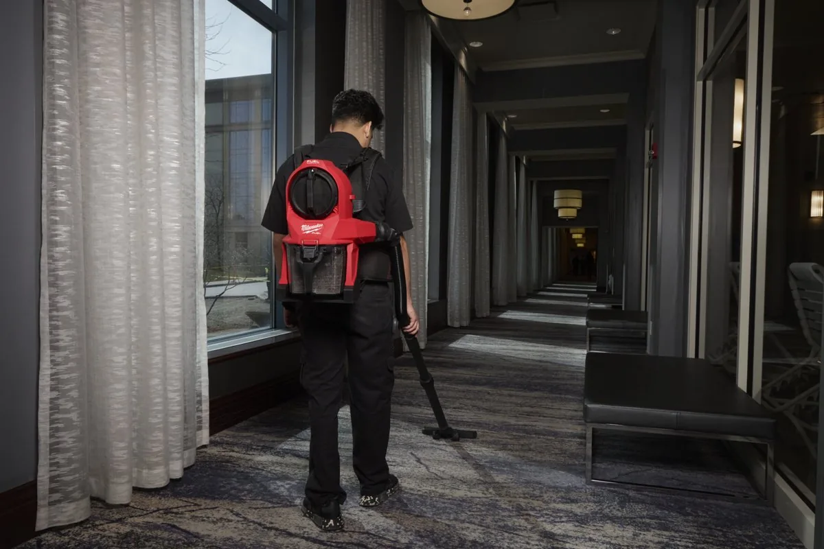 Pracownik z M18 FBPV2 odkurza korytarz hotelu