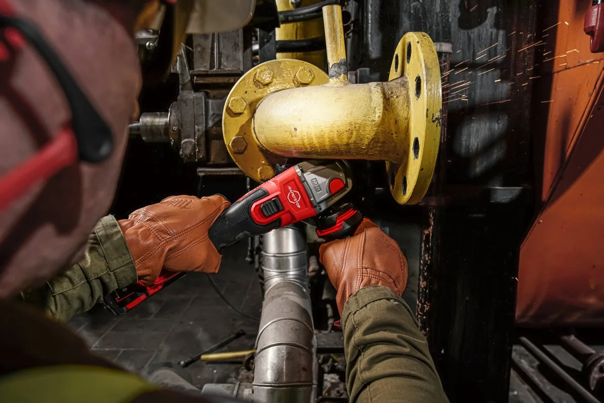 M18 FSAG125XB szlifuje kołnierz rurociągu w instalacji przemysłowej