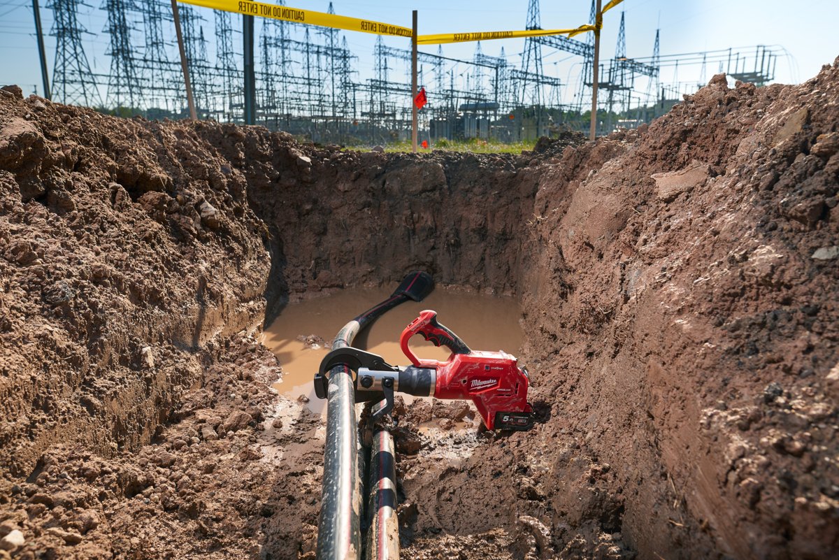 Hydrauliczne nożyce MILWAUKEE założone na kabel w głębokim wykopie przy stacji energetycznej