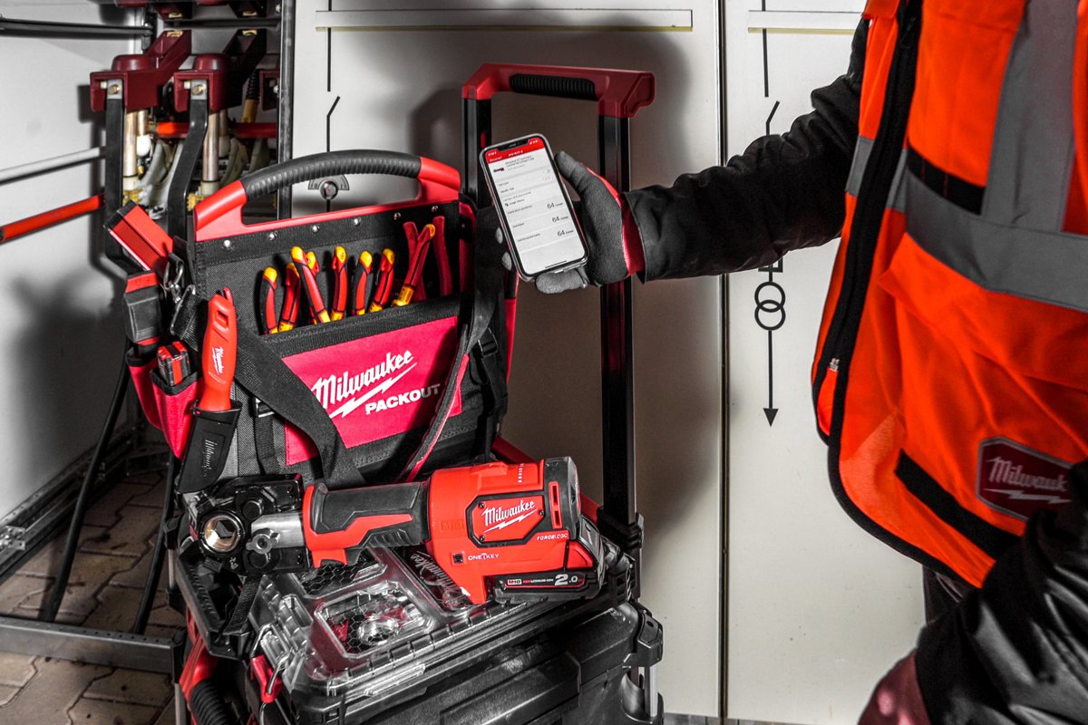 Elektryk z telefonem przy wózku PACKOUT z zaciskarką M18 HCCT