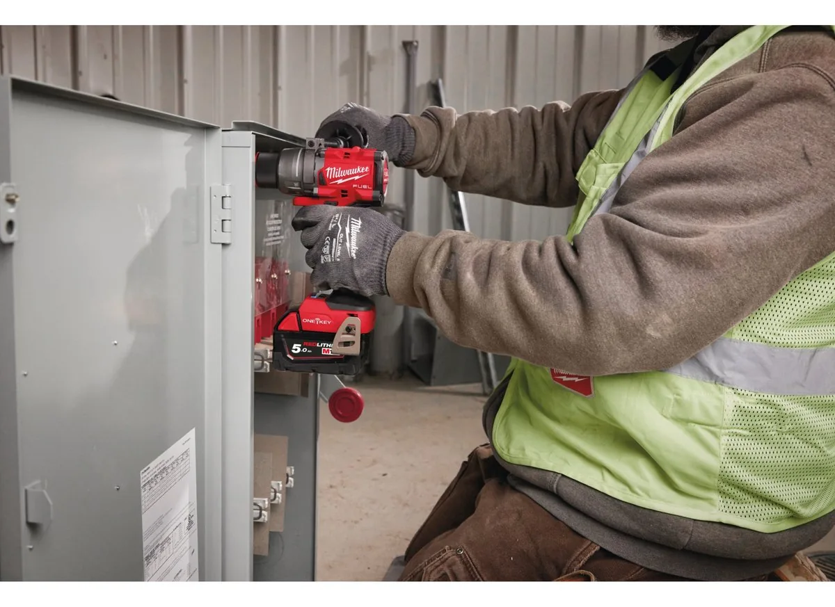 Elektryk wkręca M18 ONEDD3 w obudowie rozdzielni