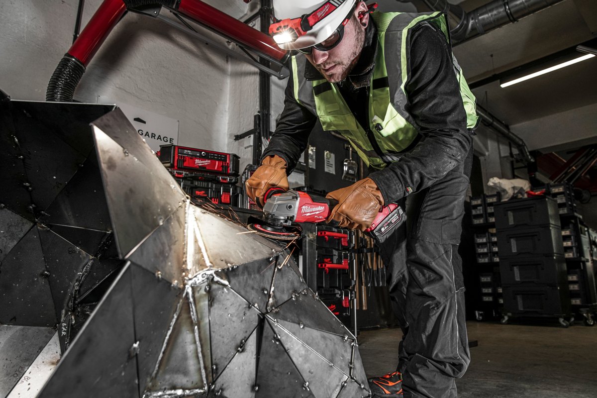 Pracownik tnie M18 ONEFSAG125XPDB stalowy element, snop iskier
