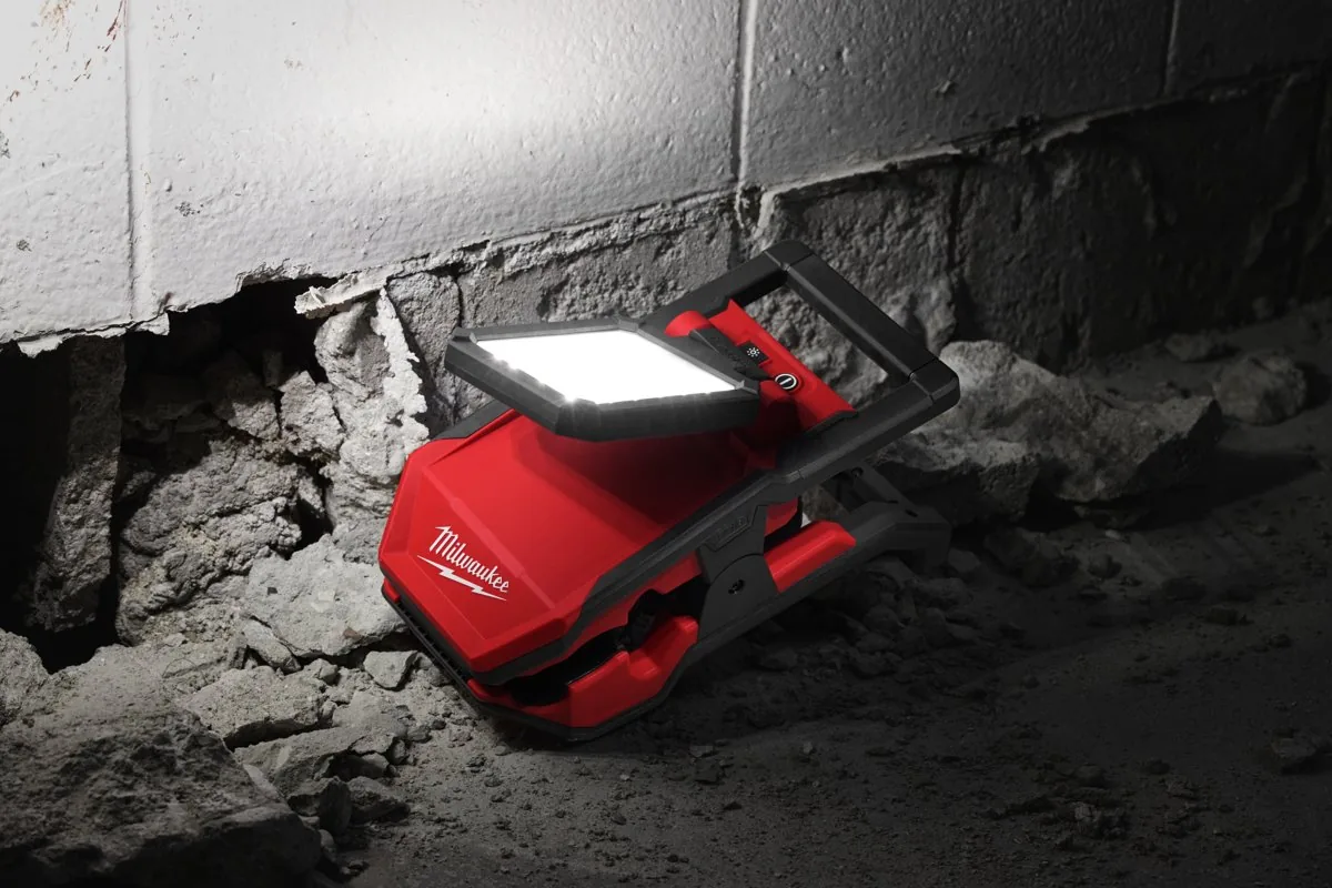 Lampa M18 PAL2 leżąca na gruzie świeci na budowie